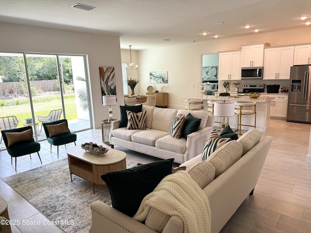 living area with visible vents, recessed lighting, and a chandelier