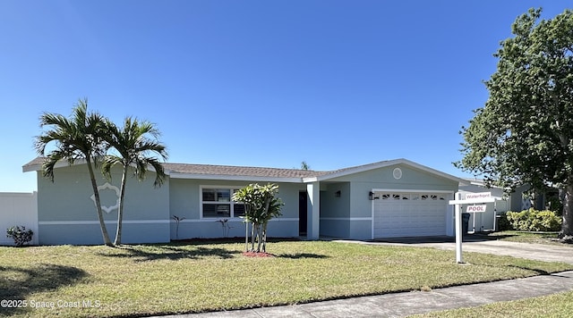 ranch-style house featuring a garage, stucco siding, concrete driveway, and a front lawn