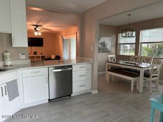 kitchen featuring hanging light fixtures, white cabinetry, dishwasher, and ceiling fan with notable chandelier