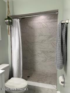 bathroom with toilet, curtained shower, and vanity