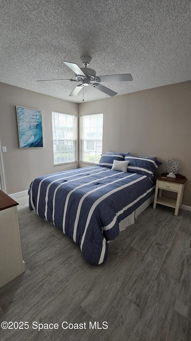 bedroom with ceiling fan and a textured ceiling