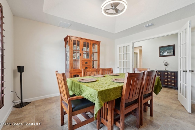 dining area featuring french doors and a raised ceiling