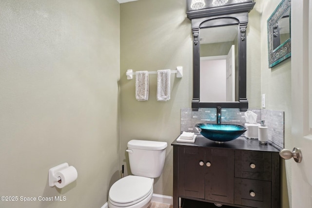 bathroom with tasteful backsplash, vanity, and toilet