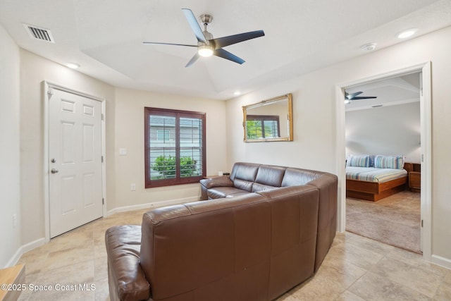 tiled living room featuring ceiling fan and a raised ceiling