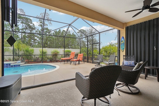 view of swimming pool with a patio, pool water feature, ceiling fan, and glass enclosure