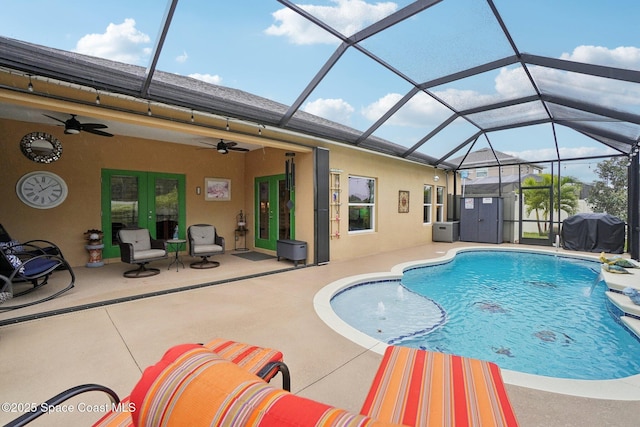 view of swimming pool with french doors, grilling area, a lanai, ceiling fan, and a patio