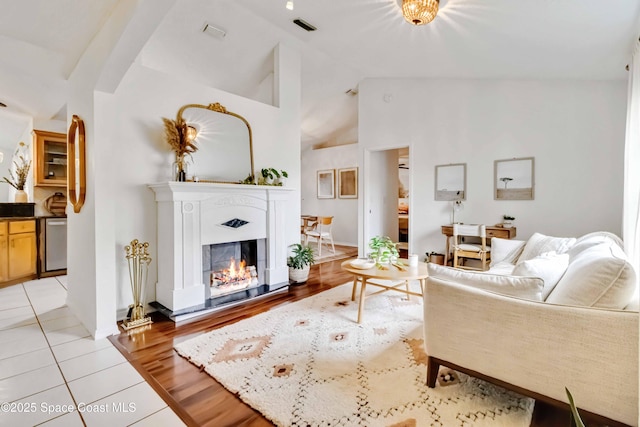 living room with high vaulted ceiling and light hardwood / wood-style floors