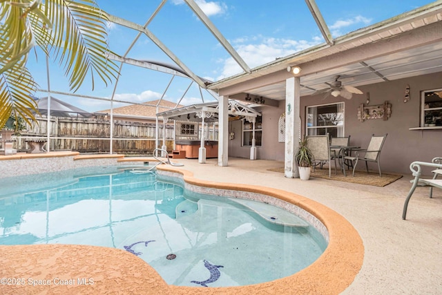 view of swimming pool with ceiling fan, glass enclosure, a jacuzzi, and a patio