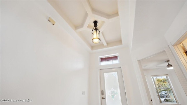 foyer entrance with coffered ceiling, ceiling fan, plenty of natural light, and beamed ceiling