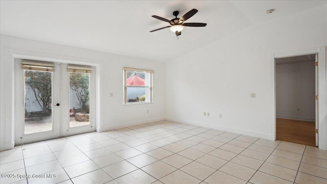 tiled spare room featuring ceiling fan and french doors