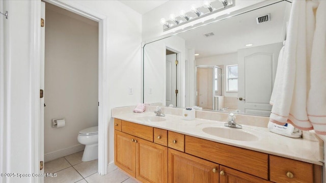 bathroom with toilet, vanity, tile patterned flooring, and walk in shower