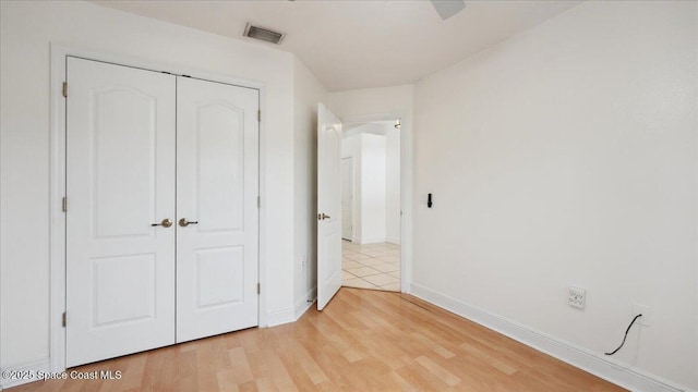 unfurnished bedroom featuring a closet and light hardwood / wood-style flooring