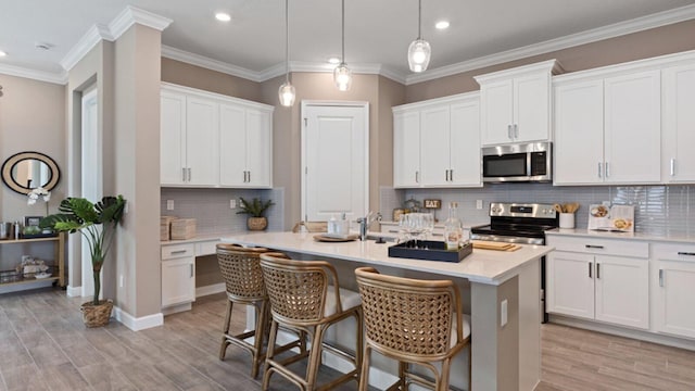 kitchen featuring stainless steel appliances, white cabinetry, and hanging light fixtures