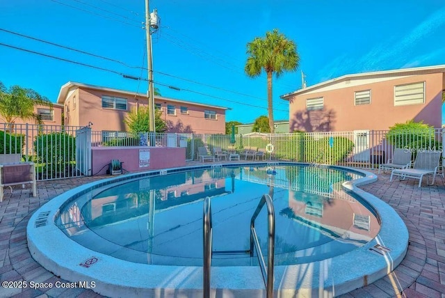 community pool featuring a patio area and fence