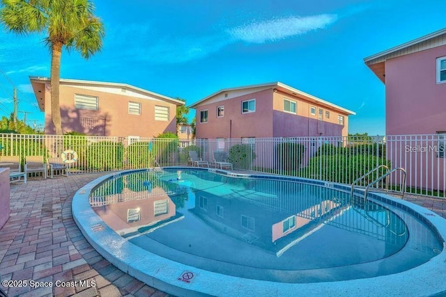 view of swimming pool featuring a patio area and fence