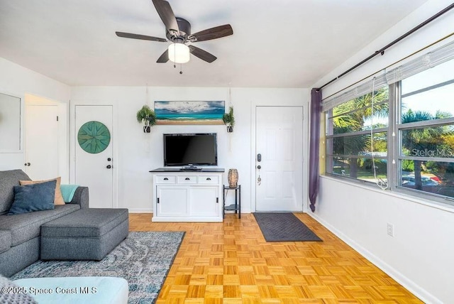 living room featuring ceiling fan and baseboards