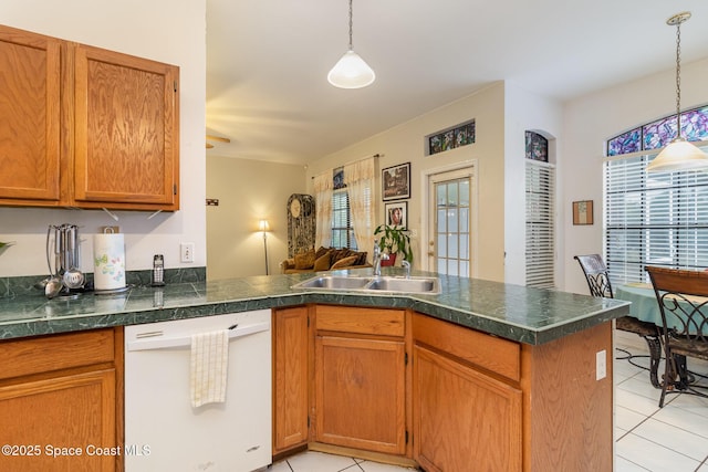 kitchen featuring white dishwasher, sink, decorative light fixtures, and kitchen peninsula