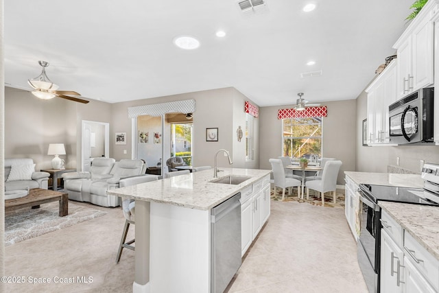 kitchen featuring sink, a kitchen island with sink, white cabinetry, and stainless steel appliances