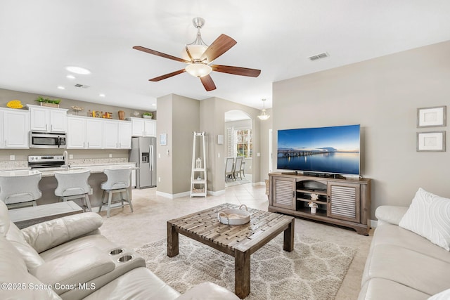 tiled living room featuring ceiling fan