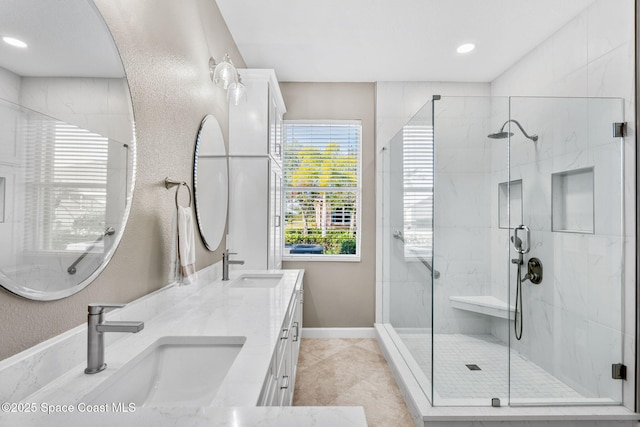 bathroom featuring a shower with shower door and vanity