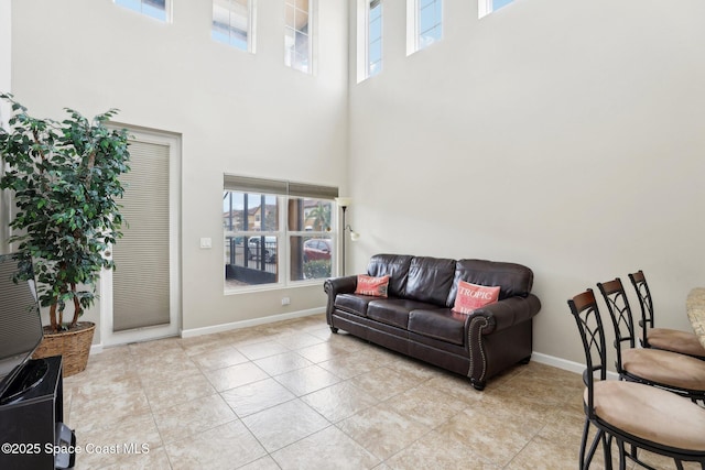 living room with a high ceiling and light tile patterned floors