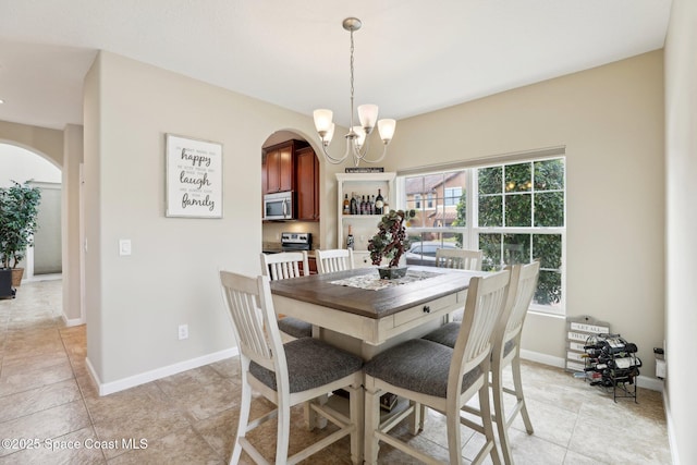 tiled dining area featuring a chandelier