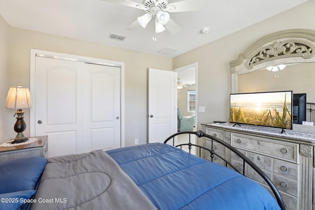 bedroom featuring a textured ceiling, ceiling fan, and a closet