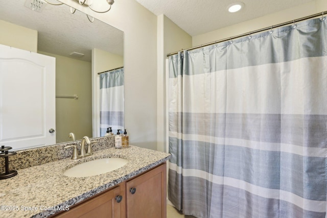 bathroom featuring a textured ceiling and vanity