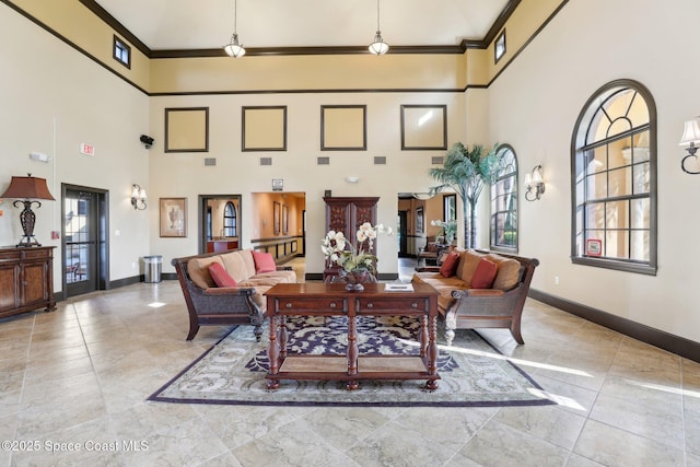 living room with a towering ceiling and crown molding