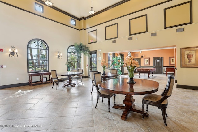 dining space featuring a towering ceiling, ornamental molding, and pool table