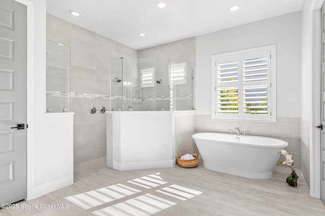 bathroom featuring tile walls and plus walk in shower