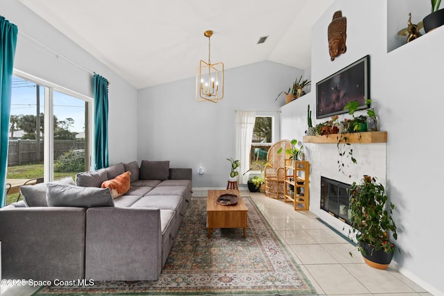 tiled living room with lofted ceiling, a chandelier, and a fireplace