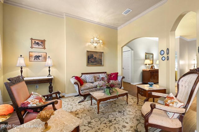 living room featuring crown molding, wood-type flooring, and a notable chandelier