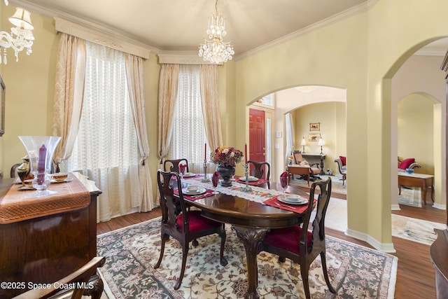 dining space featuring crown molding, a chandelier, and hardwood / wood-style flooring