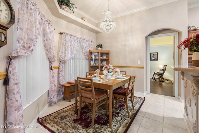 dining room with light tile patterned floors, crown molding, and a notable chandelier