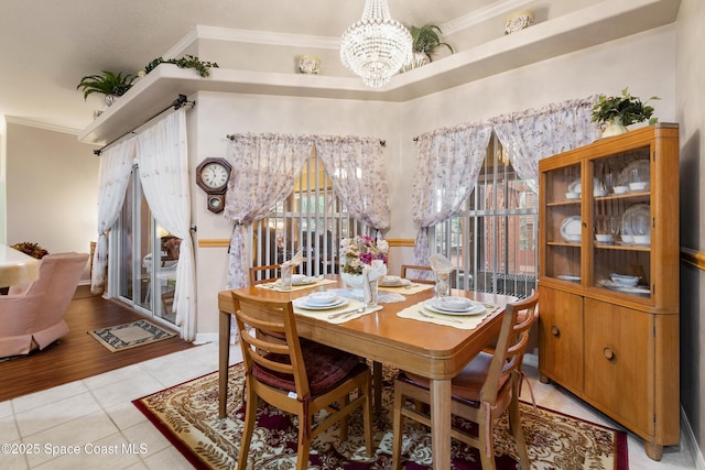 tiled dining space with crown molding and an inviting chandelier