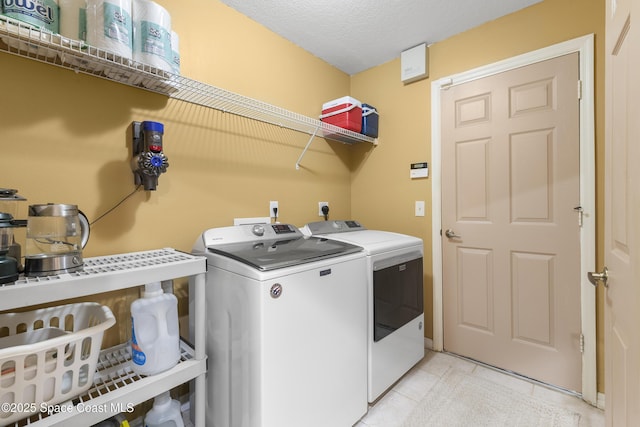 laundry area with washer and dryer and a textured ceiling