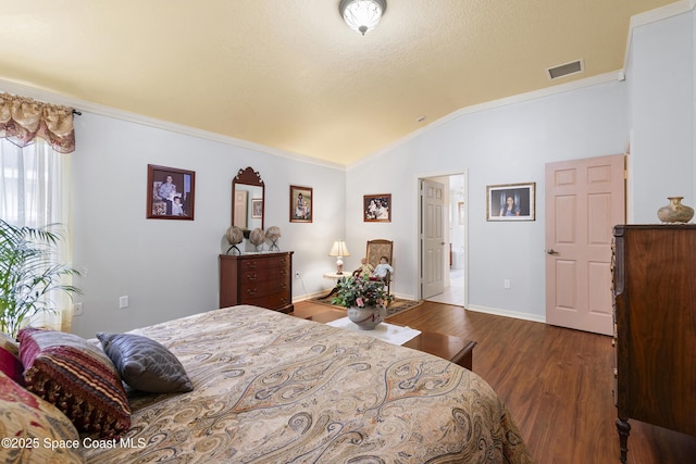 bedroom with vaulted ceiling, dark wood-type flooring, and crown molding