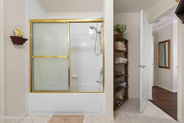 bathroom with tile patterned floors, shower / bath combination with glass door, and crown molding