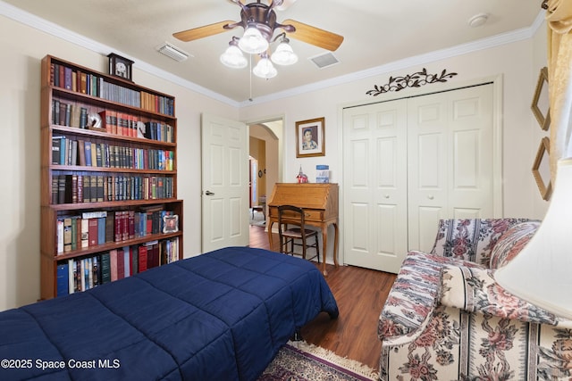 bedroom with ceiling fan, a closet, dark hardwood / wood-style flooring, and ornamental molding