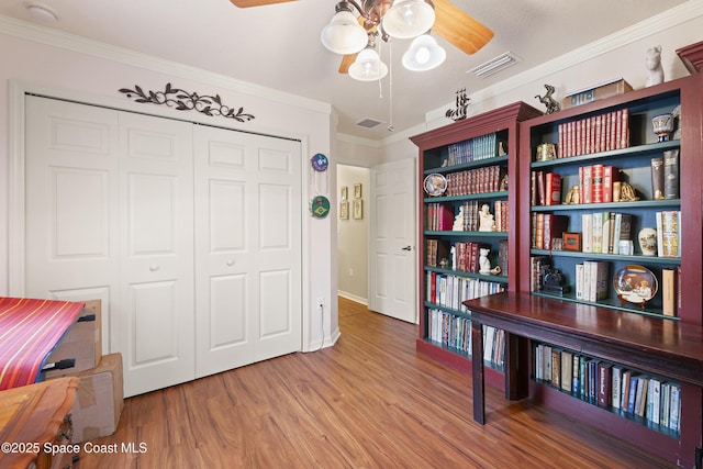 interior space featuring ceiling fan, crown molding, and hardwood / wood-style flooring