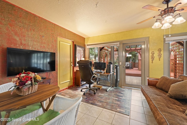 tiled home office with ceiling fan and a textured ceiling