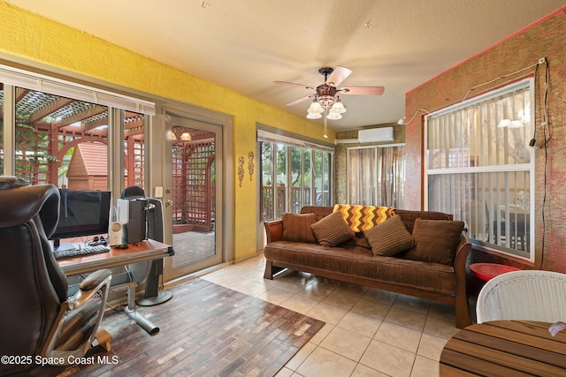 living room with ceiling fan, light tile patterned floors, a textured ceiling, and a wall mounted air conditioner