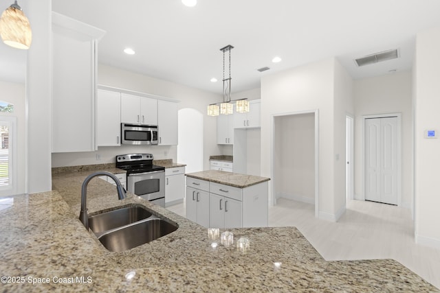 kitchen with white cabinetry, kitchen peninsula, stainless steel appliances, hanging light fixtures, and sink