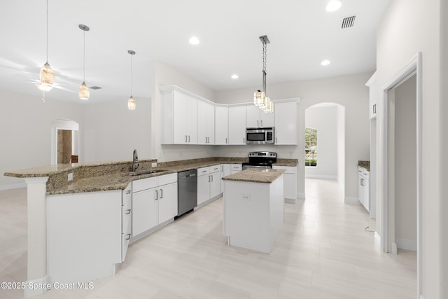 kitchen featuring kitchen peninsula, stainless steel appliances, a center island, white cabinets, and sink