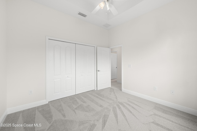 unfurnished bedroom with ceiling fan, a closet, and light colored carpet