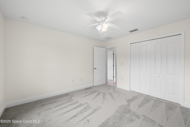 unfurnished bedroom featuring light carpet, ceiling fan, and a closet