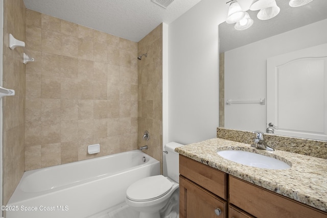 full bathroom featuring toilet, tiled shower / bath, vanity, and a textured ceiling