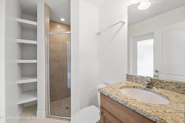 bathroom with built in shelves, tile patterned floors, vanity, toilet, and walk in shower