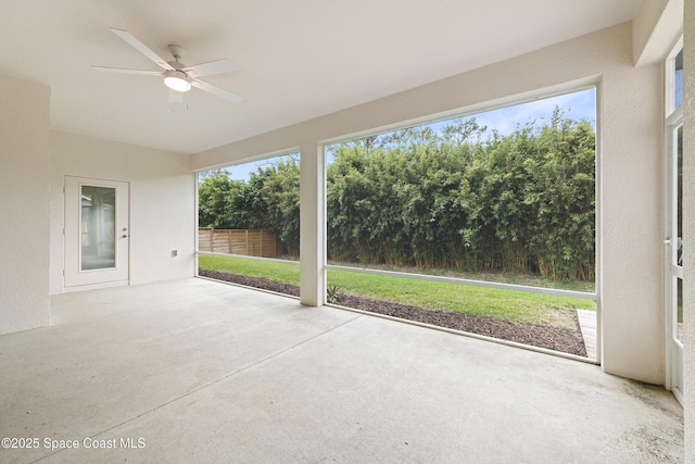 unfurnished sunroom featuring ceiling fan